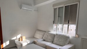 A white sofa, a white table, and a window with blinds. - Apartment for seasonal rent. Ramiro Maetzu Street pta. 7 (València)