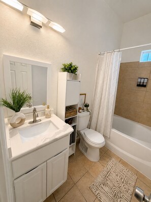 A bathroom with a white sink, mirror, toilet, and bathtub. - Modern Dallas Escape-FIFA World Cup (Dallas)