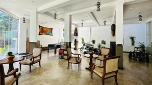 A spacious room with high ceilings, large windows, and a mix of modern and traditional furniture. - Rivora Gallery City Hotel - Kandy (Kandy)