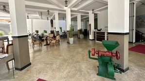 A spacious lobby with high ceilings, large pillars, and a green industrial machine. - Rivora Gallery City Hotel - Kandy (Kandy)