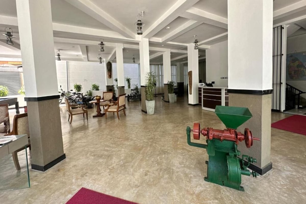 A spacious lobby with high ceilings, large pillars, and a green industrial machine.