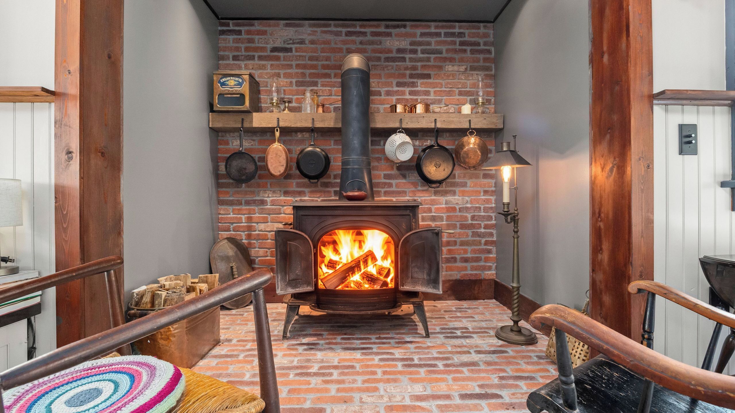 A cozy room with a brick fireplace, wooden beams, and a rustic aesthetic.