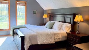 A bedroom with a bed, two bedside lamps, a ceiling fan, and a view of the outdoors. - Private 13-Acre Retreat - Pond, Kayaks, Fire Pit & Trails. Pet-friendly! (Conneautville)
