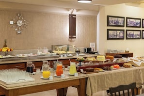 A buffet breakfast setup with various food items and beverages.
