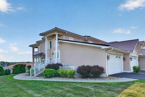 Une maison à deux étages avec un porche abrité, un garage et une pelouse bien entretenue.