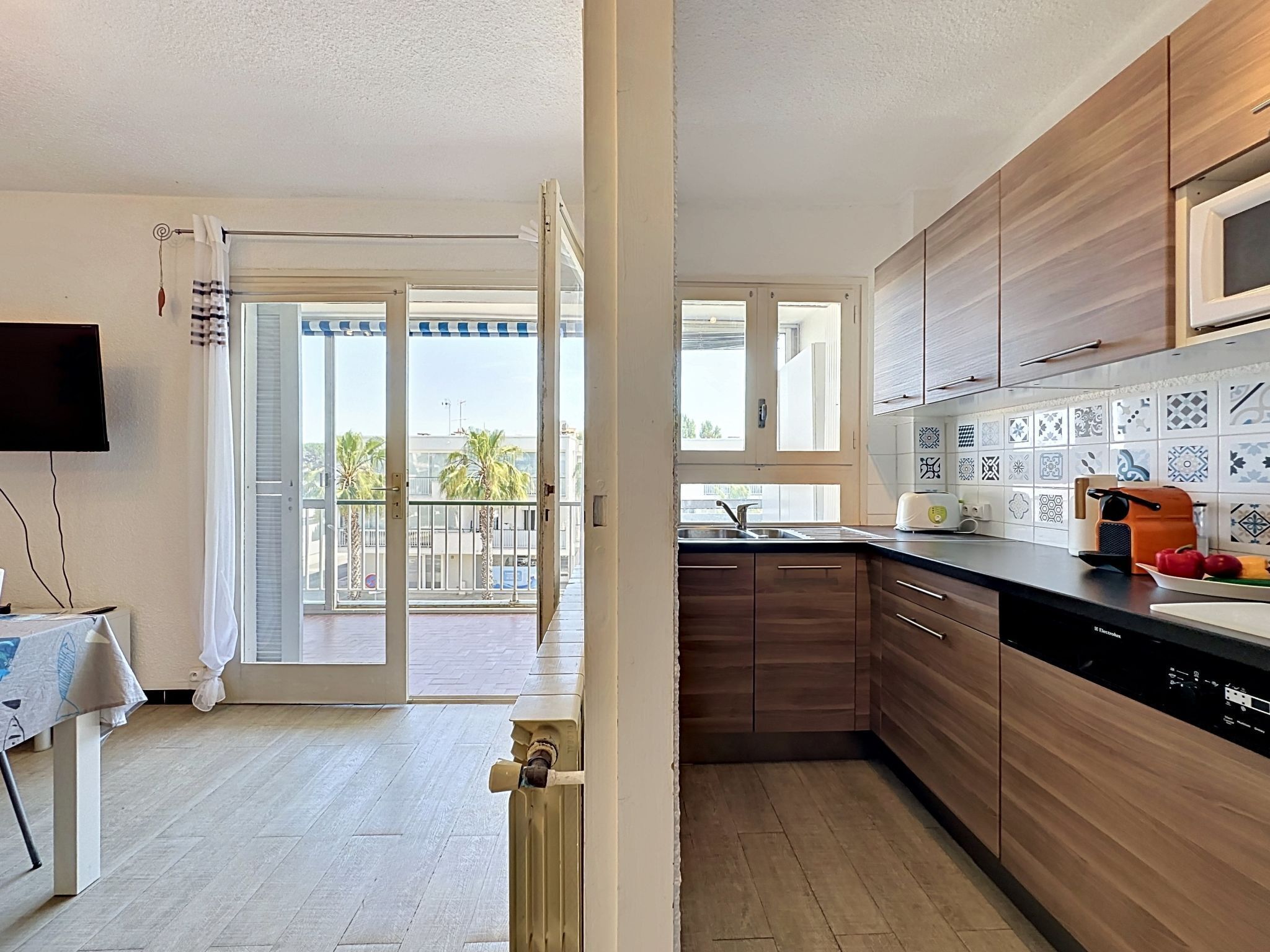 A modern kitchen with wooden cabinets, a built-in microwave, and a tiled backsplash.
