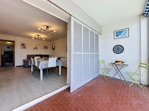Een eethoek met een tafel, stoelen en een decoratief wandobject.