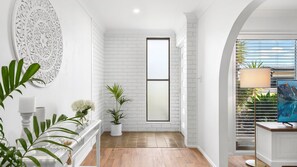 Ein modernes Interieur mit weißen Backsteinwänden, einem großen Fenster und Bergblick.