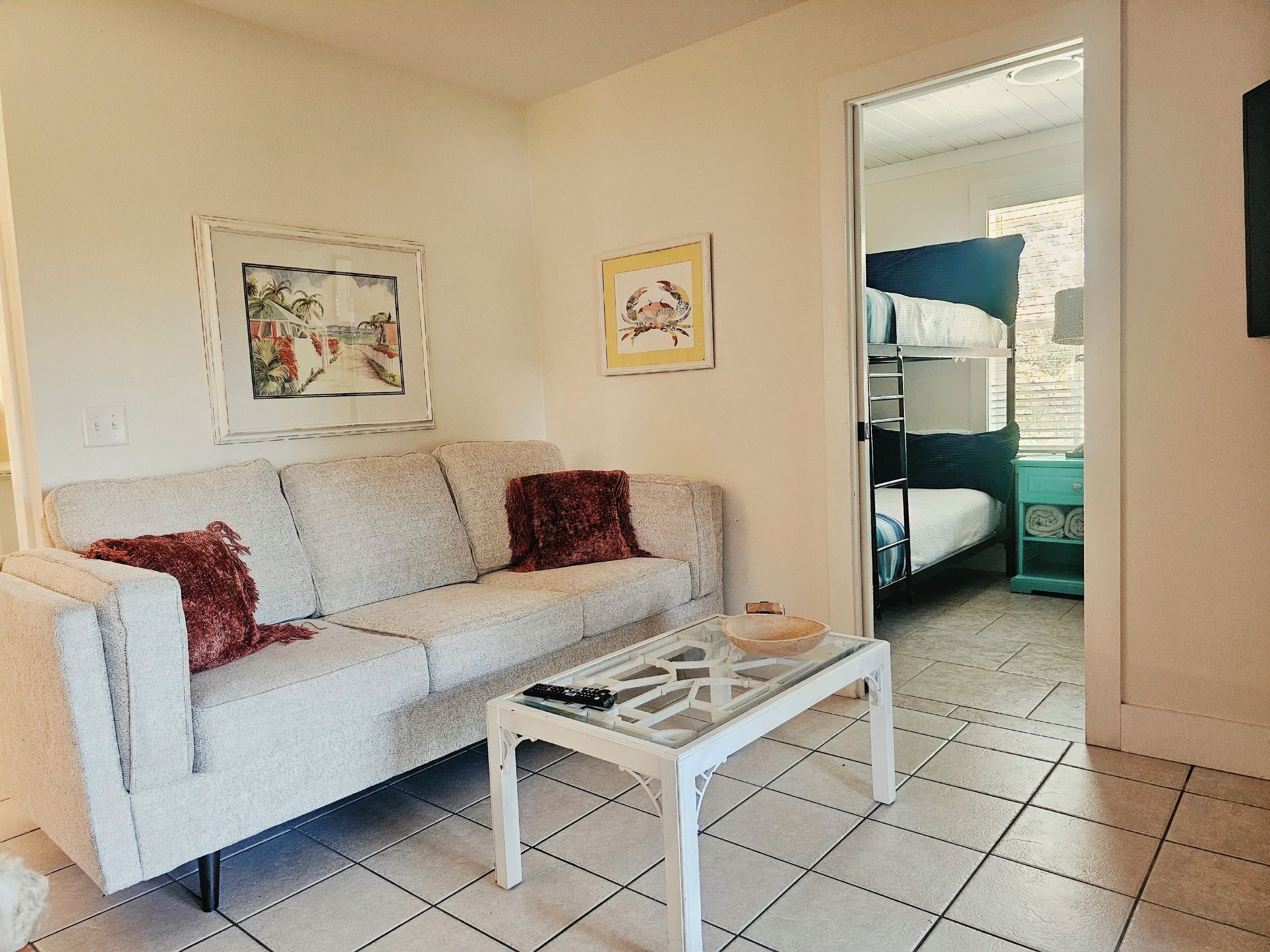 Une pièce comprenant un canapé, une table basse et un lit superposé.