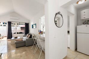 Eine moderne Wohnung mit Wohnbereich, Küche und Balkon.