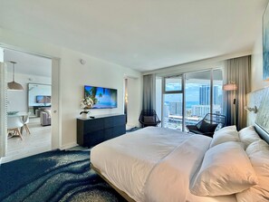 A modern hotel room with a large bed, a flat-screen TV, a view of the city, and a balcony. - 1707-Resort-2 bedrooms-AC-Gym-Pool-Beachfront-Downtown-Central (Fort Lauderdale)