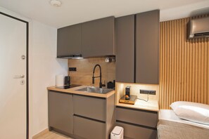 Une petite cuisine équipée comprenant un évier, une cuisinière et des placards de rangement.
