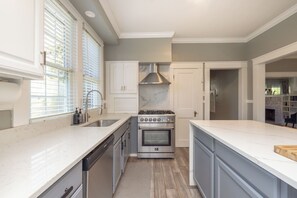 A modern kitchen with a built-in oven, stainless steel appliances, and a marble backsplash.
