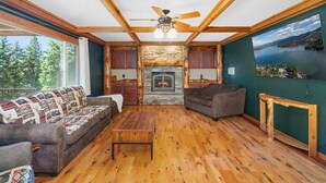 Un salon chaleureux avec une cheminée, un plancher en bois et une vue sur un lac.
