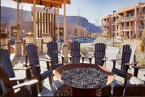 Eine Terrasse mit Adirondack-Stühlen, einer Feuerstelle und Blick auf ein Gebirge.