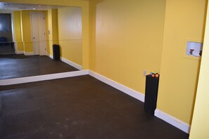 A room with a large mirror, yellow walls, a dark floor, and a small black object on the wall. - The Hill-Private Estate Near Atlanta-Huge Home, 2 Kitchens, Ideal for Gatherings (Suwanee)