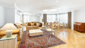 Ein geräumiges Wohnzimmer mit einer Sofagarnitur, einem Couchtisch und einem gemusterten Teppich.