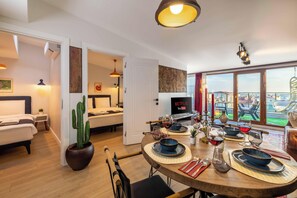 A modern living room with a dining area, a large window with a view, and a flat-screen TV. - Panoramic Bosphorus View Terrace At Monnas Suite (Istanbul)