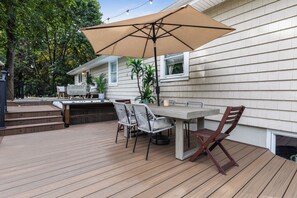 An outdoor patio with a table and chairs, a barbecue grill, and a large umbrella. - Summer Retreat: Private Pool, Jacuzzi, Game room & more (Centereach)