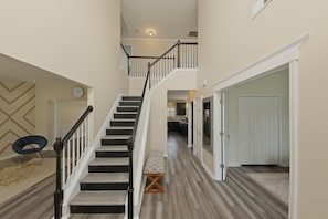 Ein mehrgeschossiges Interieur mit einer Treppe, einer Sitzbank und einer Tür zu einem weiteren Raum.