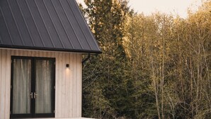 Un bâtiment moderne doté d’un toit en pente, d’une grande porte coulissante et d’un espace d’entrée plat.