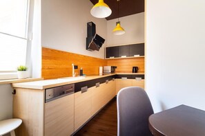 Cozinha moderna com armários de madeira, micro-ondas embutido e máquina de café.