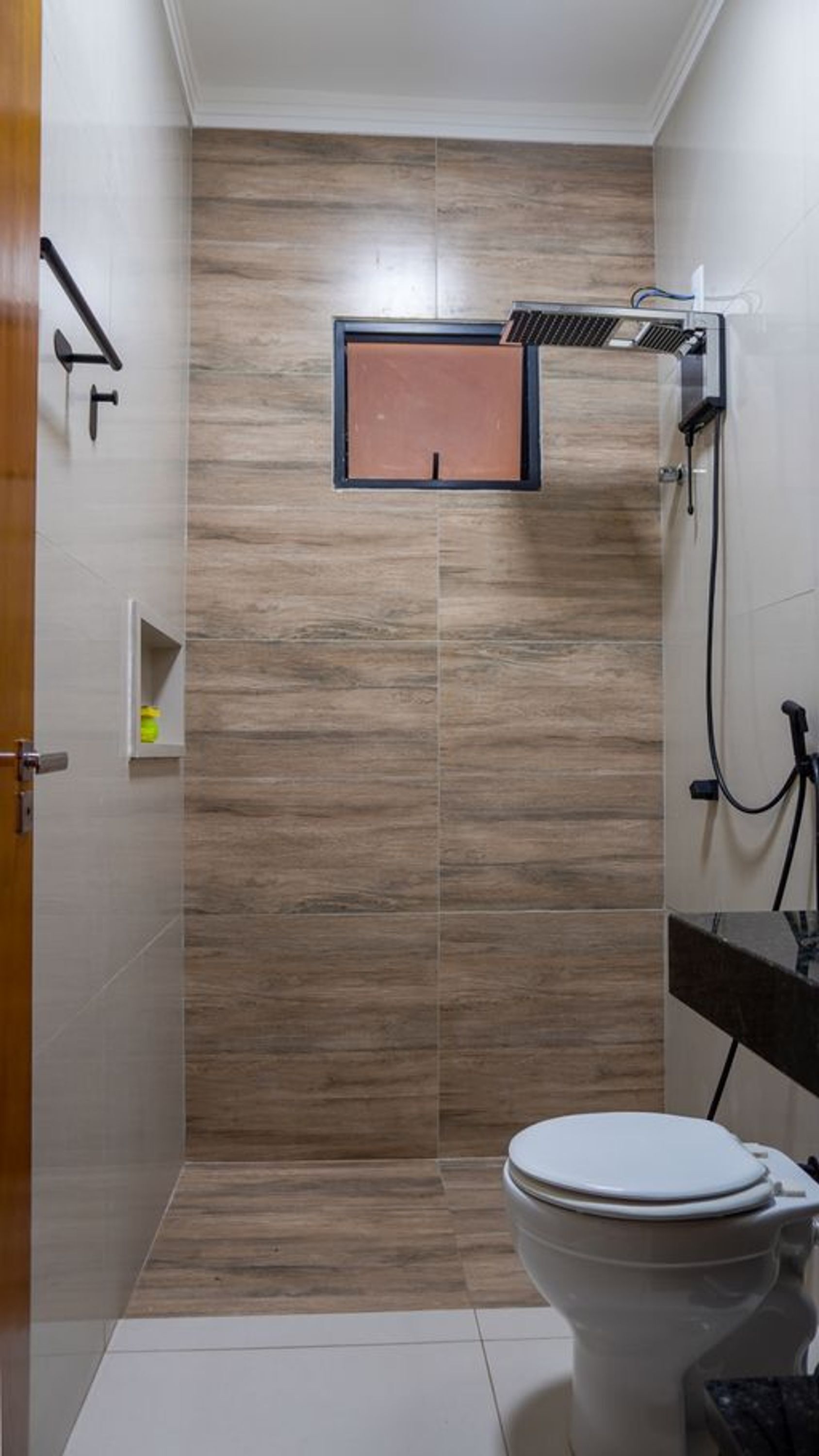 A small bathroom with a toilet, a shower area, and a sink.