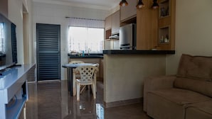 Een moderne keuken met een eethoek, een bank en een televisie.