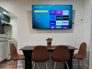 Ein Flachbildfernseher an der Wand, der eine Streaming-Oberfläche mit verschiedenen App-Symbolen zeigt.