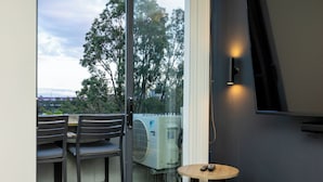 Ein Balkon mit Tisch, Stühlen und einer Klimaanlage.