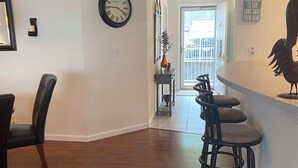 A modern kitchen with a bar area, wooden flooring, and a clock on the wall. - Charming 2 bedroom lakefront condo with access to 3 outdoor pools in Osage Beach (Osage Beach)