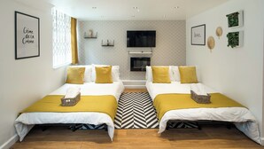 A hotel room with two beds, a TV, and a fireplace. - Central London Gem | Sleeps 8 | Hyde Park | London (London)
