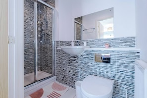 A bathroom with a glass shower enclosure, a white sink, and a toilet. - The Eastern Hive - 3x Parking | Co-op Live&Etihad (Greater Manchester)