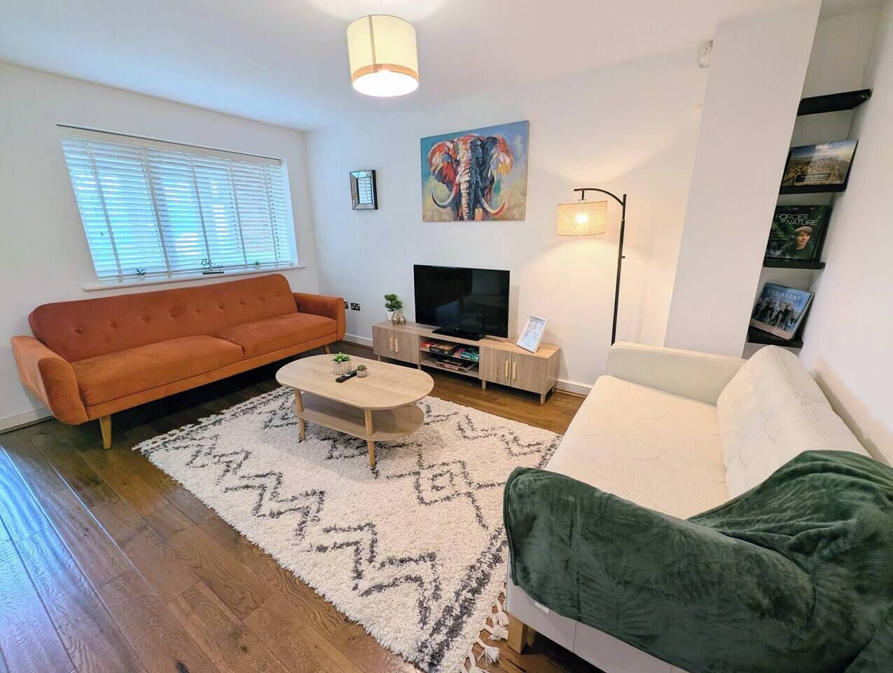 A living room with a sofa, a coffee table, a TV, and a lamp.