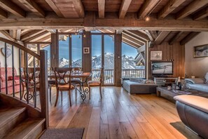 Ein Holzinterieur mit Essbereich, Sofa und Fernseher.