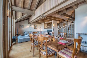 Ein Essbereich mit Holzmöbeln, eine Treppe und ein Wohnzimmer mit einer Couch.