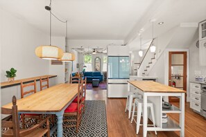 A spacious kitchen with a dining area, white cabinetry, and a staircase leading to another level. - Hill East, Barney Circle 2-BR, Walk to METRO Stop (Washington)