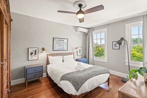 A bedroom with a bed, a ceiling fan, a nightstand, a desk, a window, and a plant. - Hill East, Barney Circle 2-BR, Walk to METRO Stop (Washington)