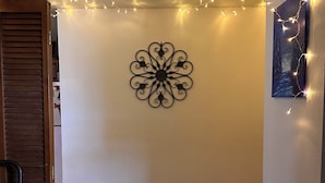 A room with a decorative wall piece, string lights, a vent, and a chair. - Cozy room, Quiet home (Arcata)