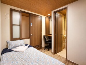 Ein Schlafzimmer mit Bett, Schreibtisch und Bad.