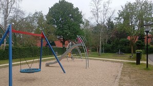 Une aire de jeux avec des balançoires et des structures d’escalade.