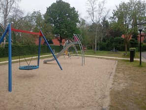 Une aire de jeux avec des balançoires et des structures d’escalade.