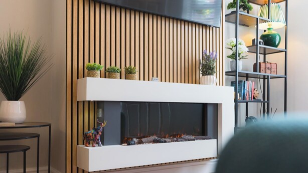 A modern living room with a fireplace, wooden slats, a bookshelf, and a potted plant.