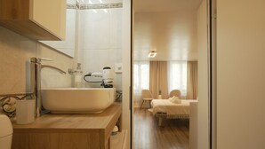 Un baño moderno con un lavabo grande, espejo y tocador de madera.