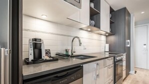 Una cocina moderna con lavavajillas, cafetera y fregadero.
