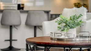 Een moderne keuken met een eethoek, bestaande uit een ronde tafel en een potplant.