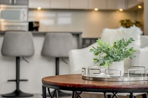 Eine moderne Küche mit Essbereich, ausgestattet mit einem runden Tisch und einem Blumentopf.