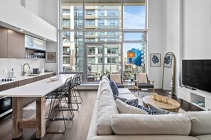 A modern kitchen with a dining area, a sofa, and a TV. - Executive Luxury Loft in Downtown Victoria (Victoria)
