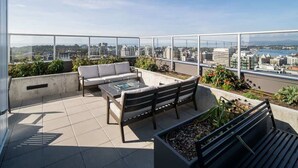 A rooftop terrace with a sofa, chairs, and a coffee table. - Affluent Executive Suite w/ Parking (Victoria)