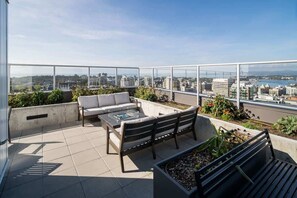 A rooftop terrace with a sofa, chairs, and a coffee table. - Affluent Executive Suite w/ Parking (Victoria)